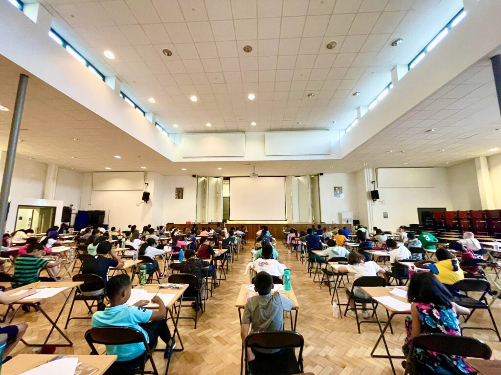 Rows of pupils sitting an exam in a large hall