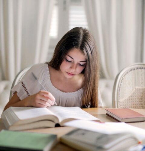 A secondary pupil studying with textbooks