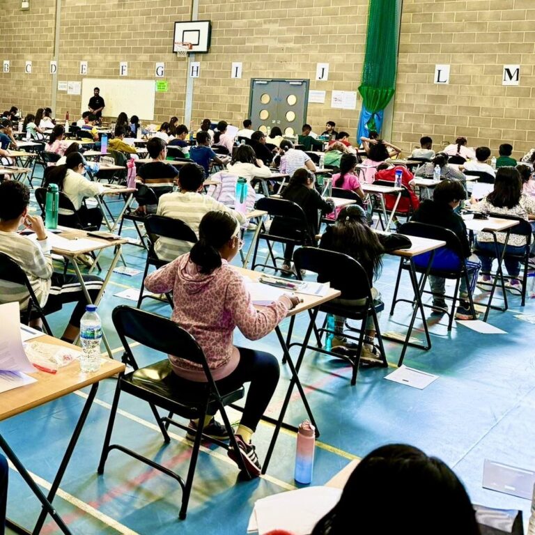 Children sitting a Pillai Tutors mock exam in a school hall